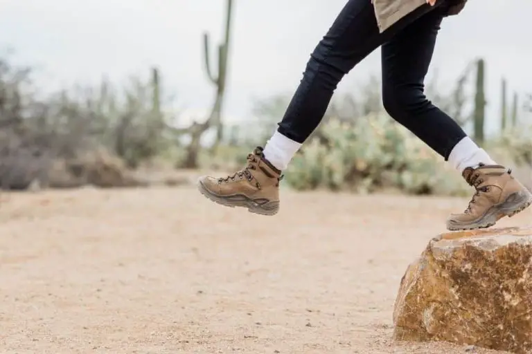a girl wearing hiking boots jump from a rock in Joshua Tree