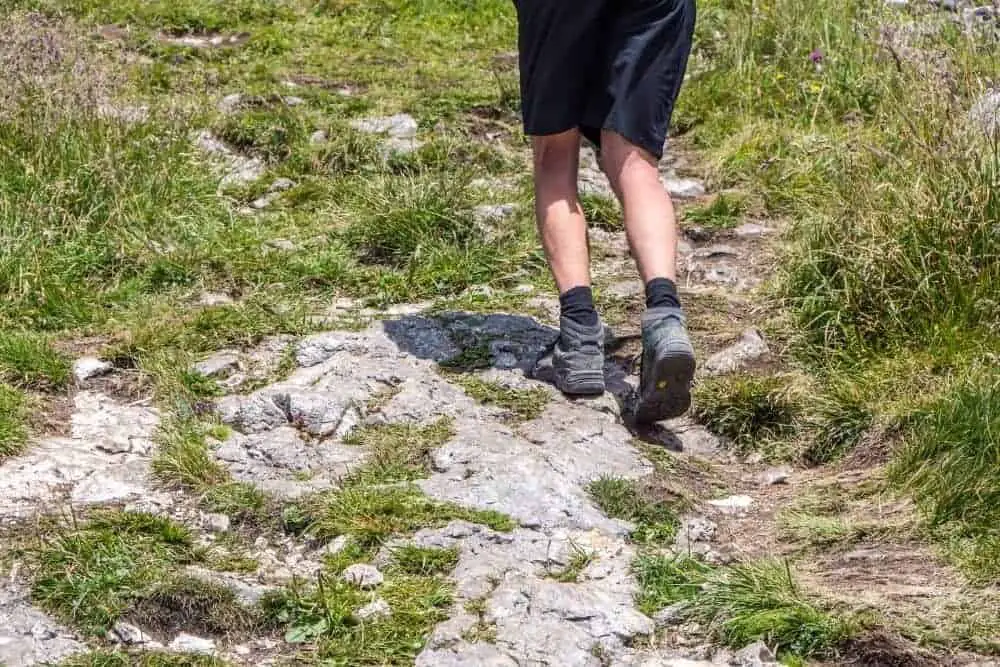 man wearing high collar hiking boots which may lead to ankle pain