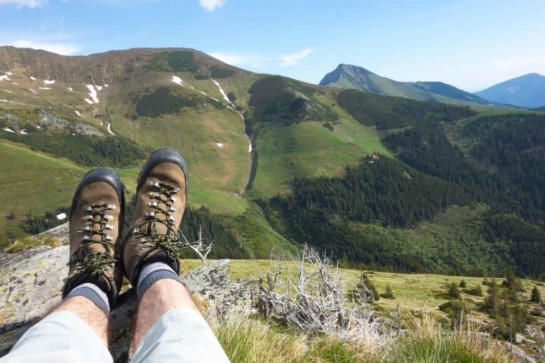 man wearing big hiking boots on mountain