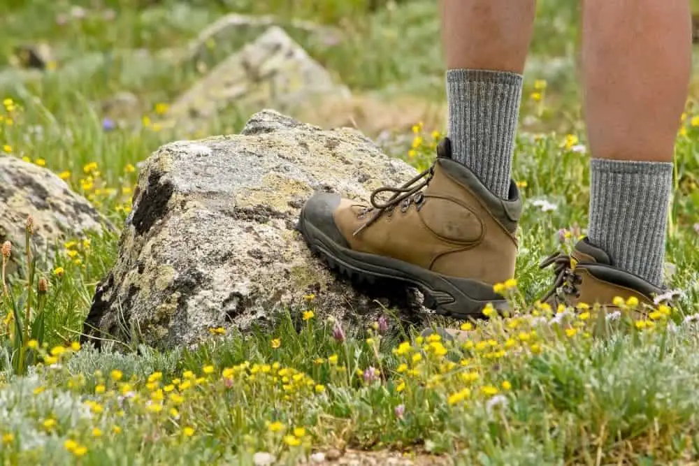 man wearing gray tall socks with hiking boots