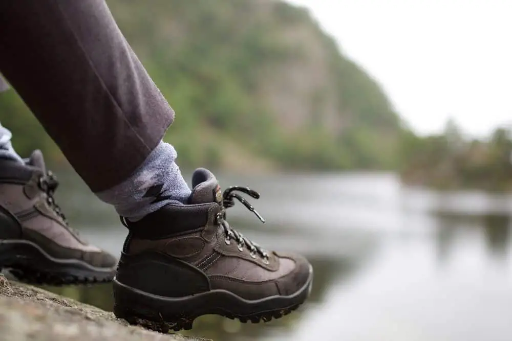 man wearing hiking boots to stretch them
