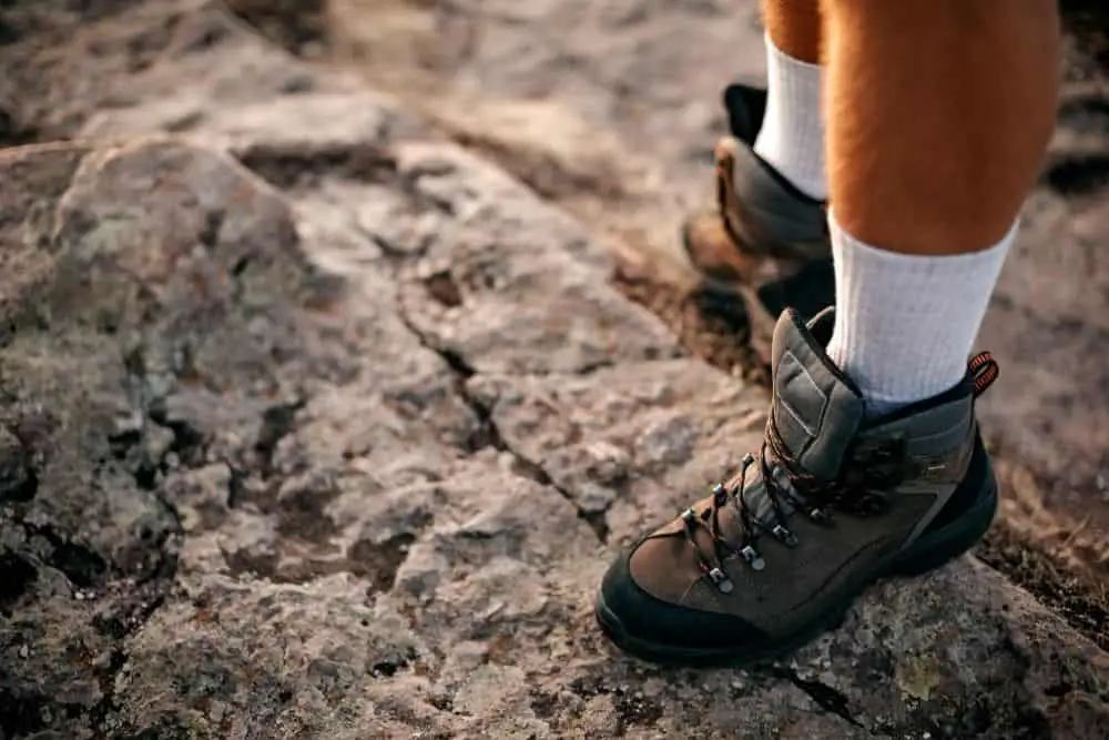 man wearing hiking boots with socks to stretch them