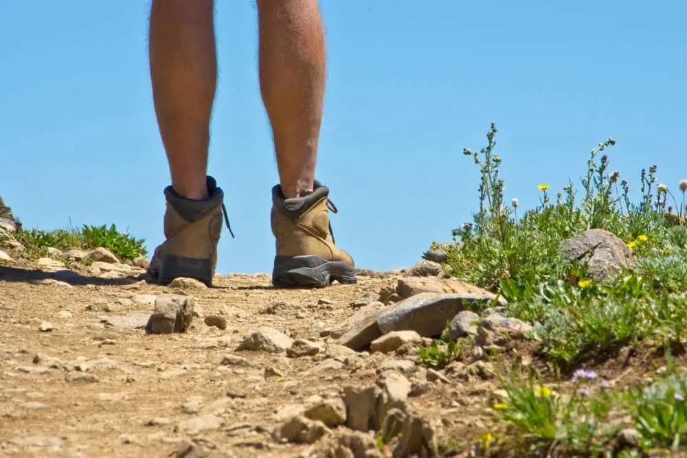 man wearing stiff hiking boots on rocky terrain