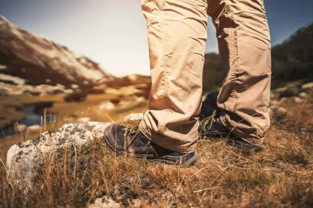 man wears khakis pants and hiking boots