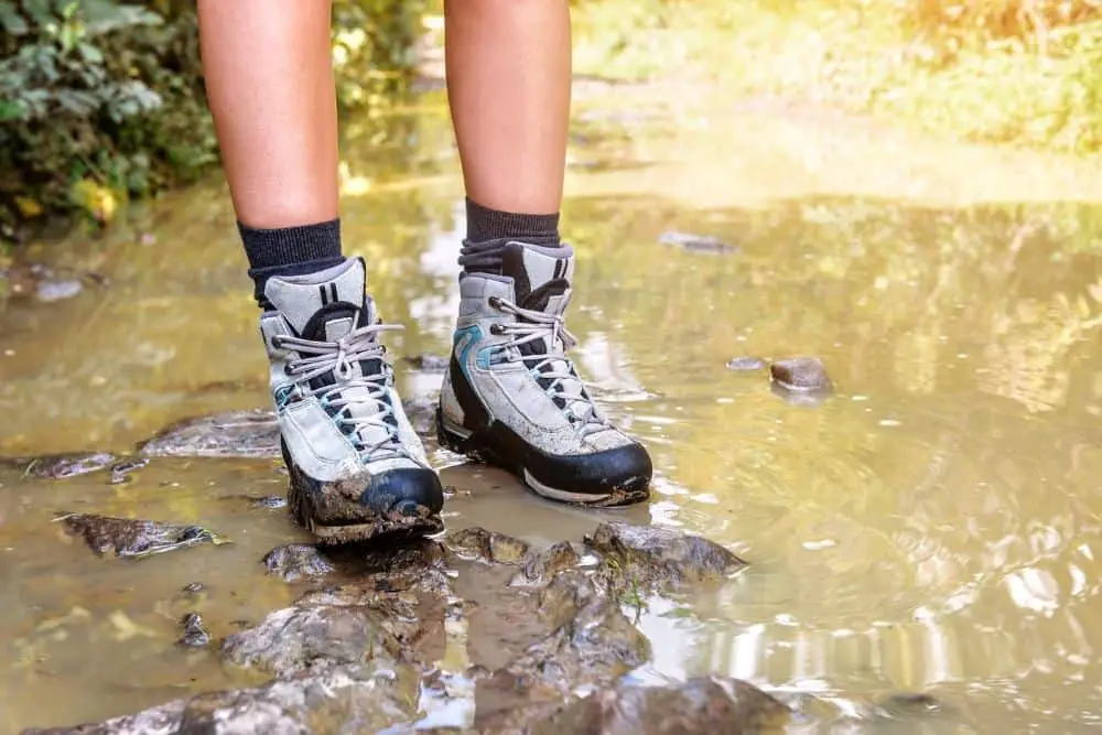 women wear hiking boots stand on the muddy and wetness place