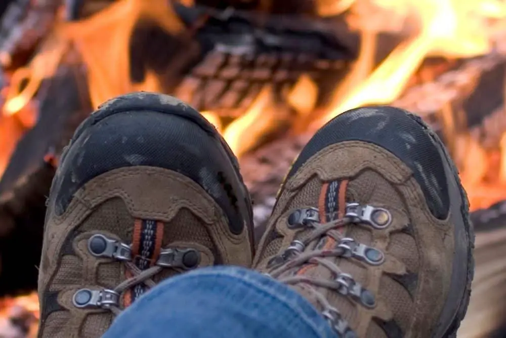 Dry hiking boots using campfire
