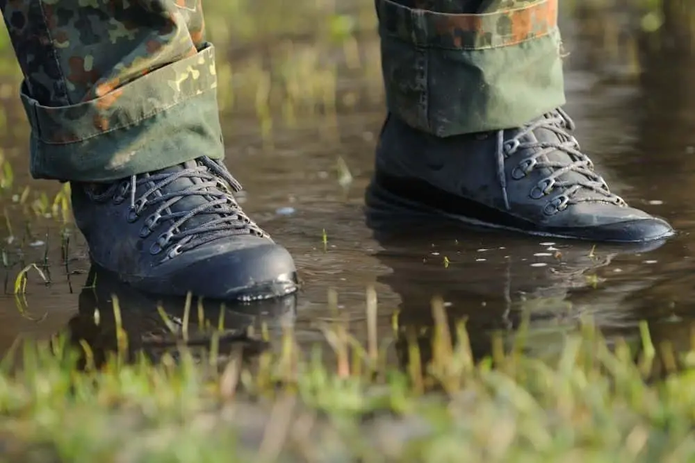 hiking boots with soles submerged in shallow water