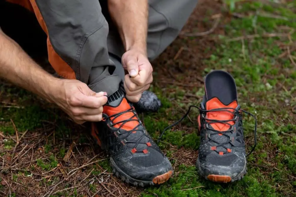 man changes the insole of hiking boots