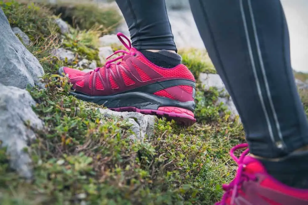women using pink hiking boots climbing on a mountain