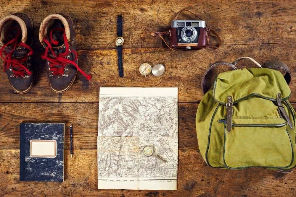 hiking boots, watch, camera, map, notebook, compass, backpack for hiking trip