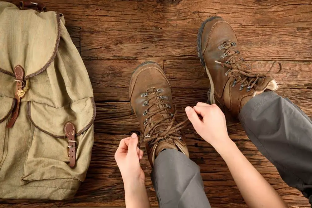 man ties hiking boots to prevent blisters