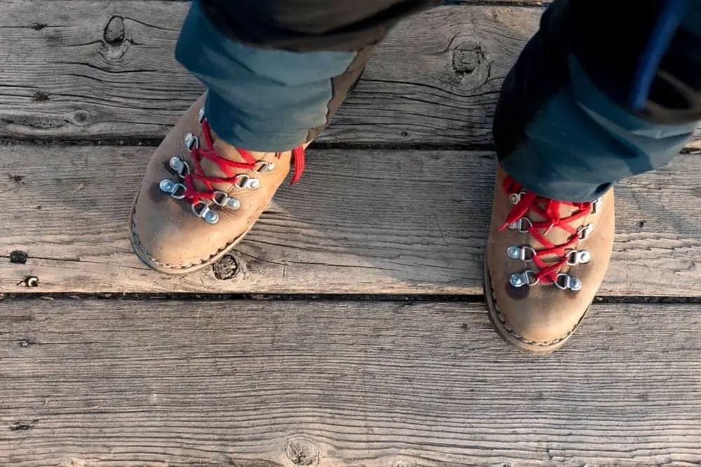 man wearing brown hiking boots with red laces