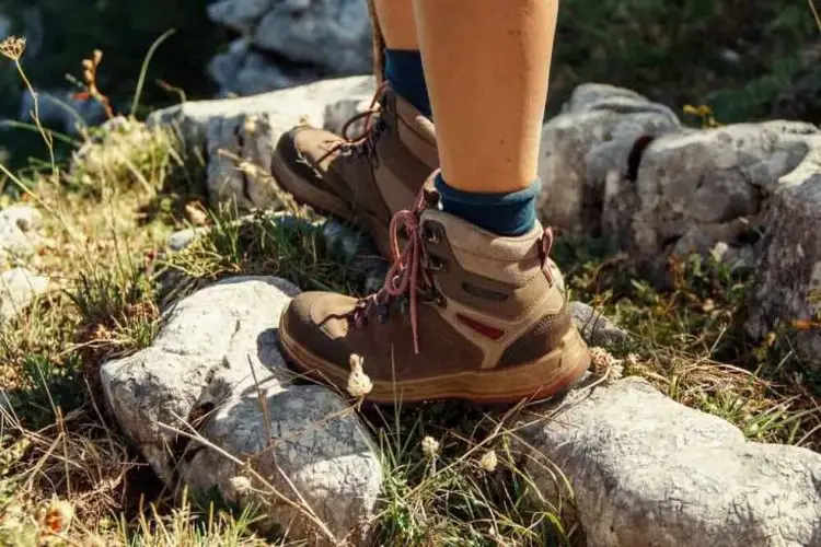 man wears hiking boots with right fit standing on stony area