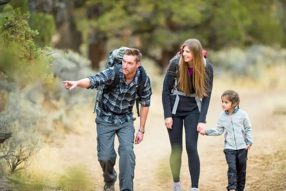 woman wearing yoga pants with hiking boots going hiking with her family