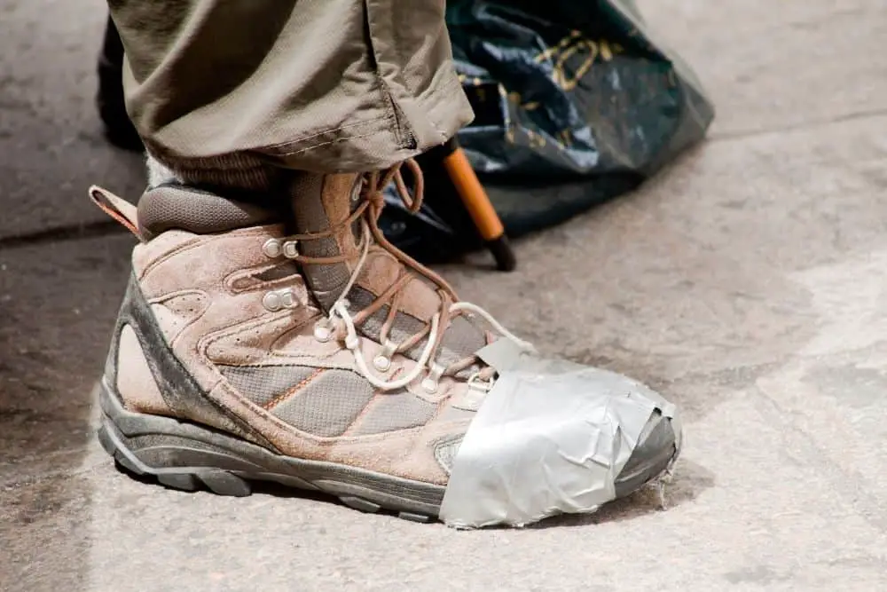 Man wear broken hiking boots