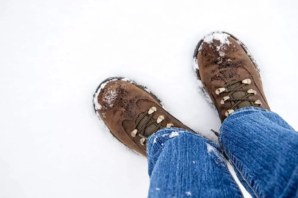 Men wear hiking boots and jeans in the snow