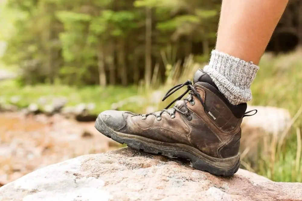Men wear hiking boot stand on the rock