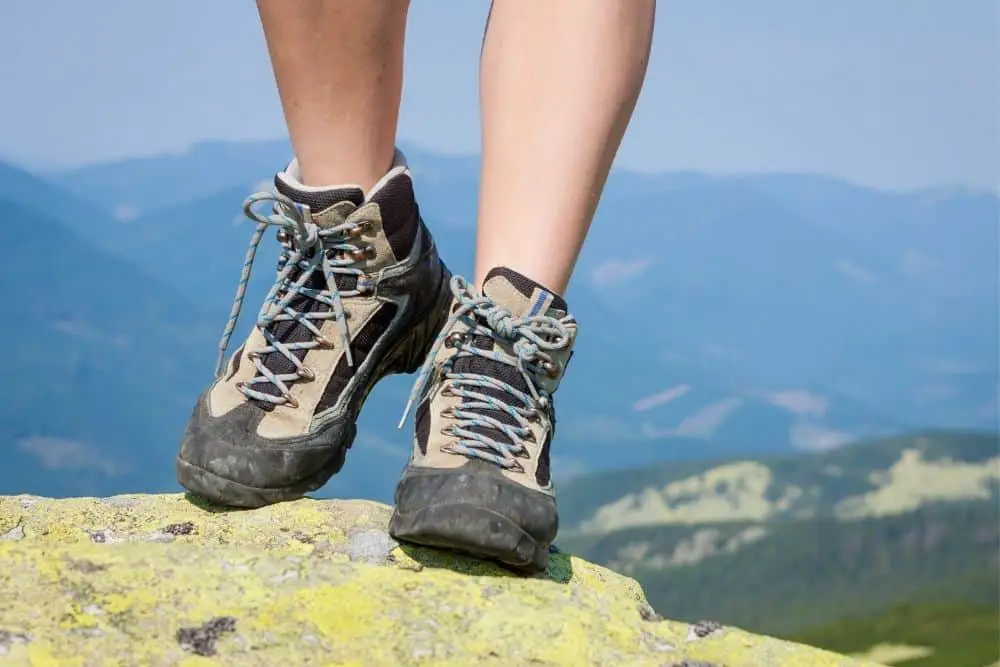 Women wear hiking boots stand on the rocky mountain