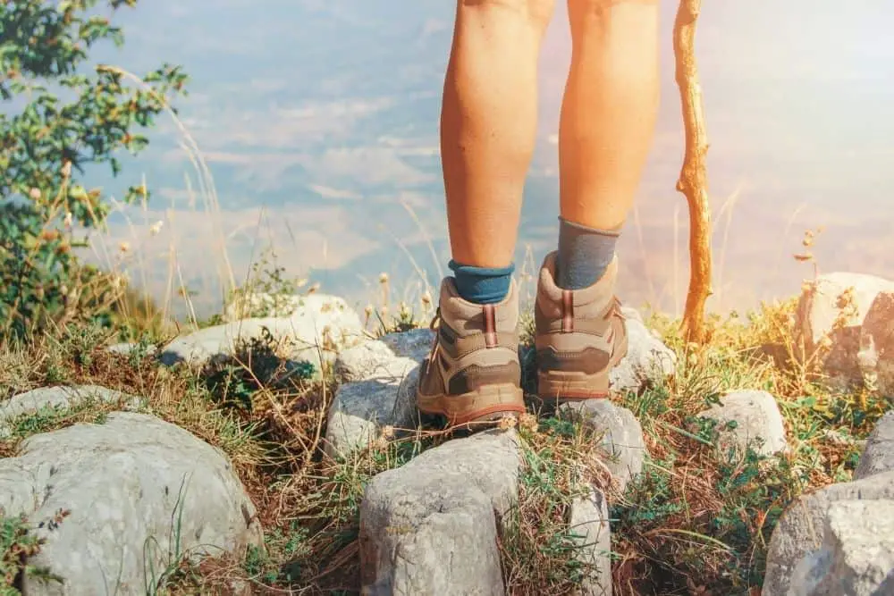 man wearing a right fit hiking boots standing on rocky terrain
