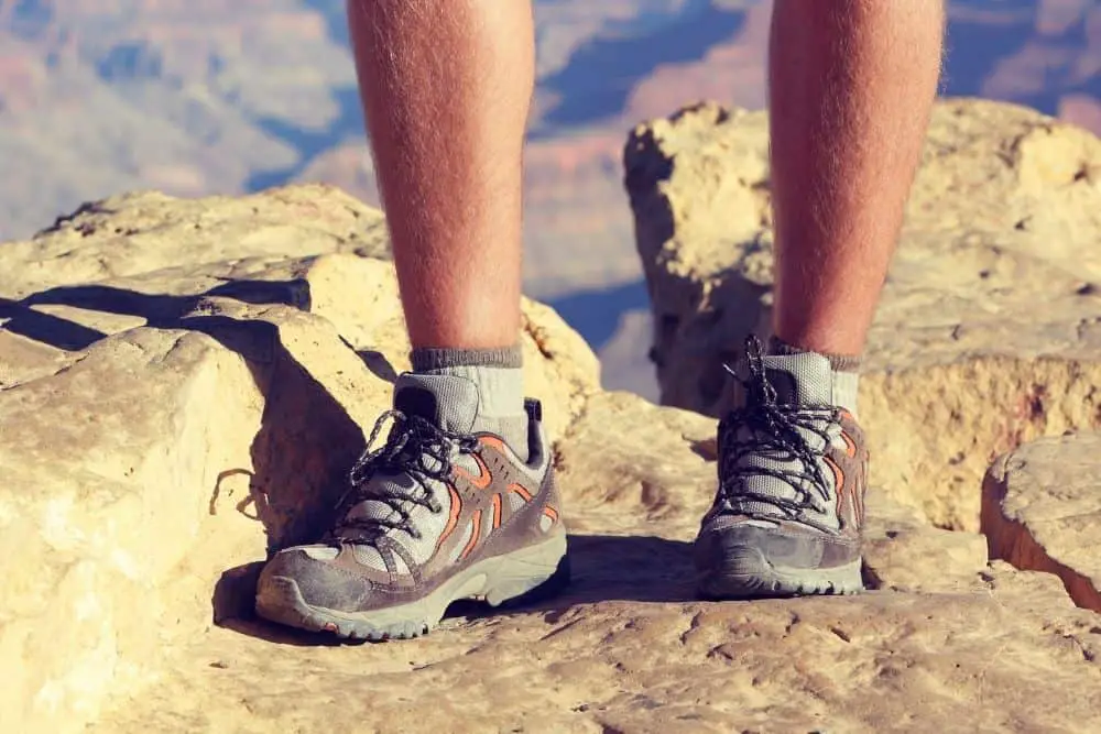 man wearing hiking boots on rocky mountain