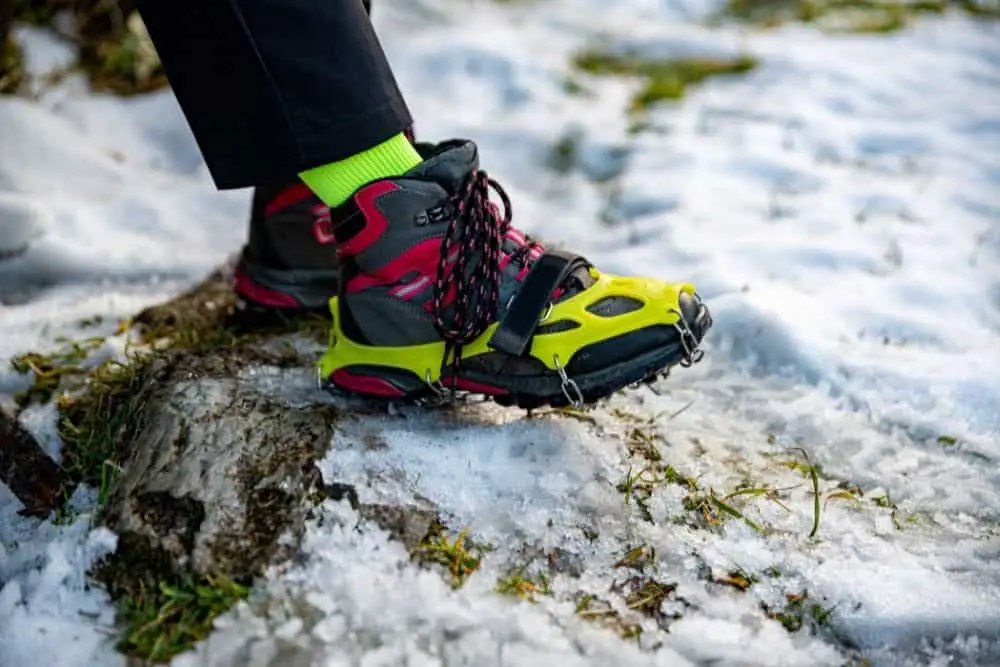 green Crampons With red Hiking Boots in snow