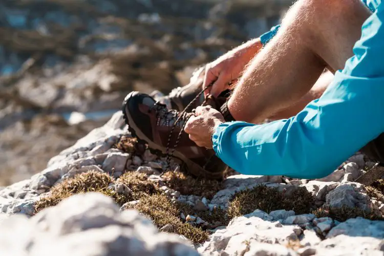 man tying hiking boot laces