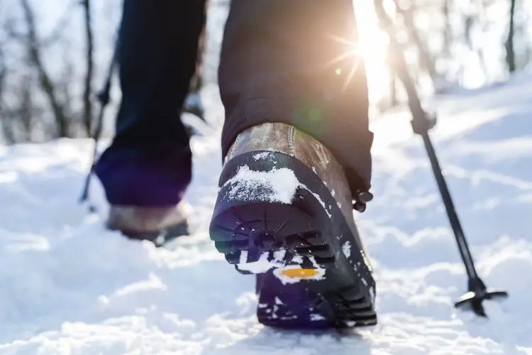 person wearing hiking boots on snow
