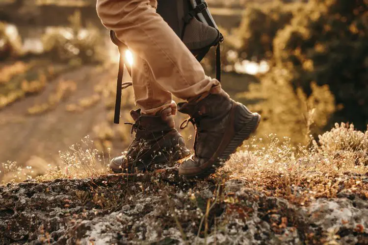 a man is going hiking on forest with hiking boots