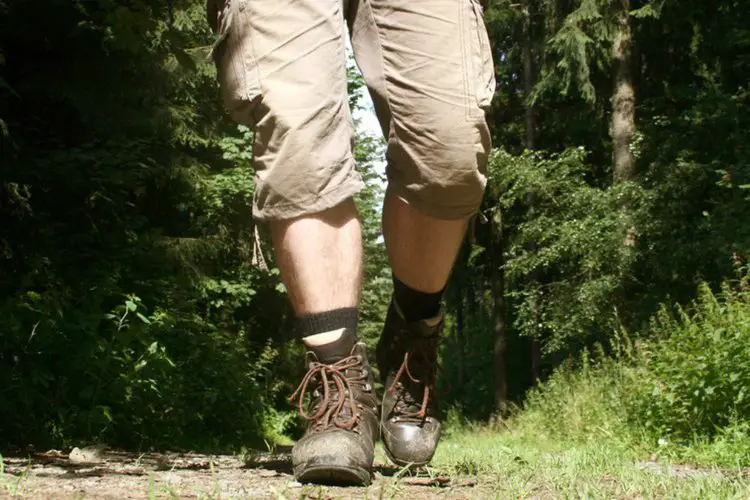 a man wears leather hiking boots on long distance hike