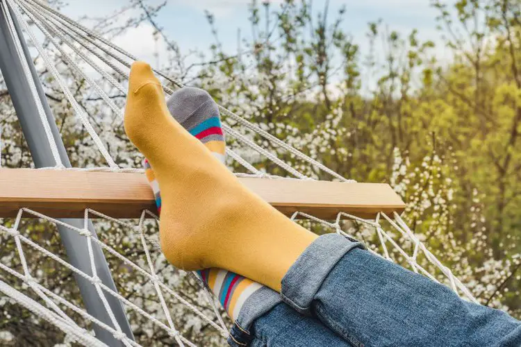 a woman wears dry socks lying on hammock