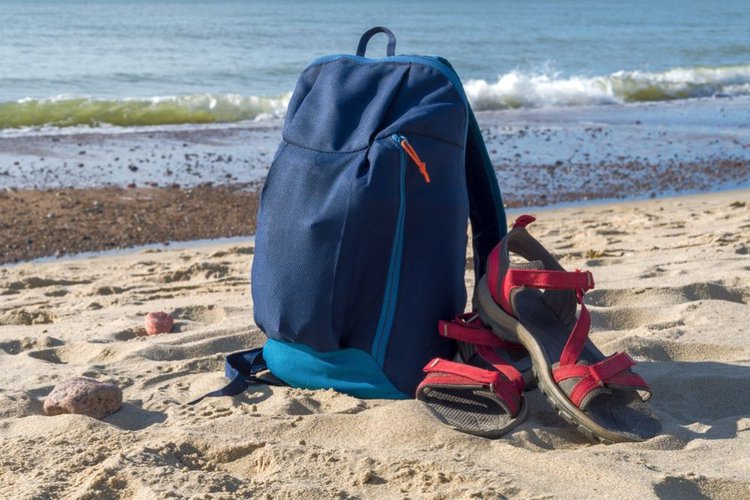 backpack and hiking sandals on the beach