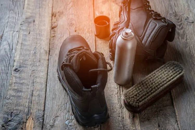 care for leather hiking boots with a spray bottle and brush