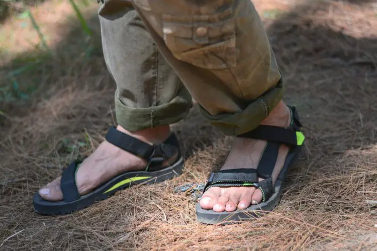 man wears hiking sandals and brown pants