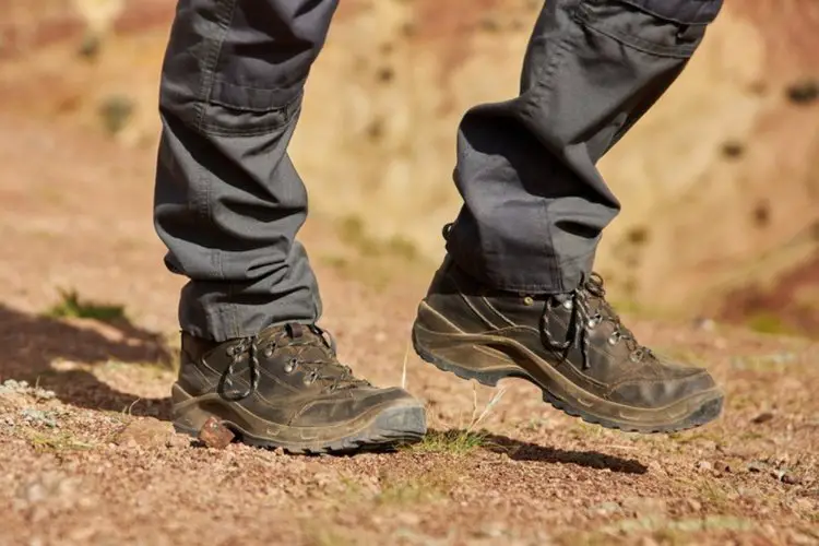 man wears leather hiking boots in the sun