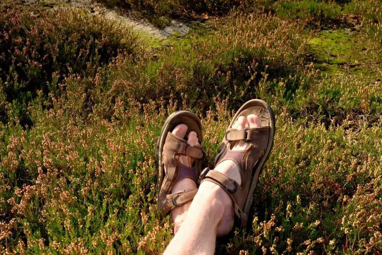 man with hiking sandals relax on the grass