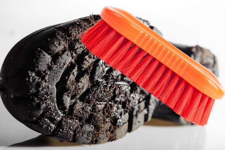 use stiff bristled brush to clean muddy hiking boot sole