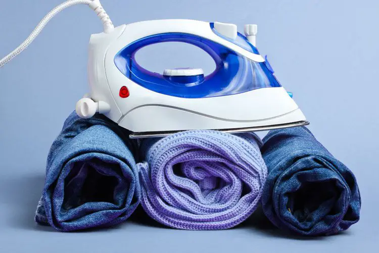Rolled clothes and the iron on the top
