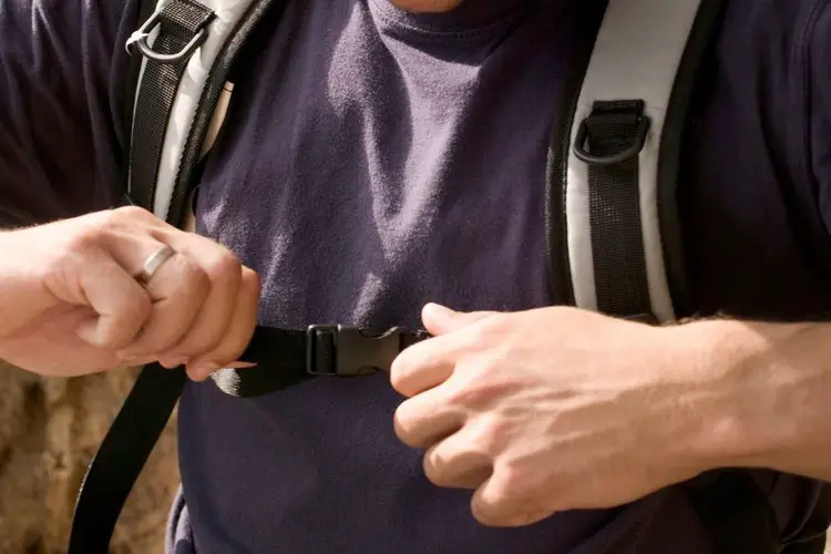 a man adjusts the sternum stap of hiking backpack