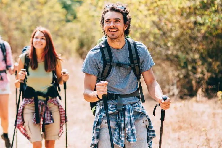 a man and woman wear hiking backpacks with hip belts
