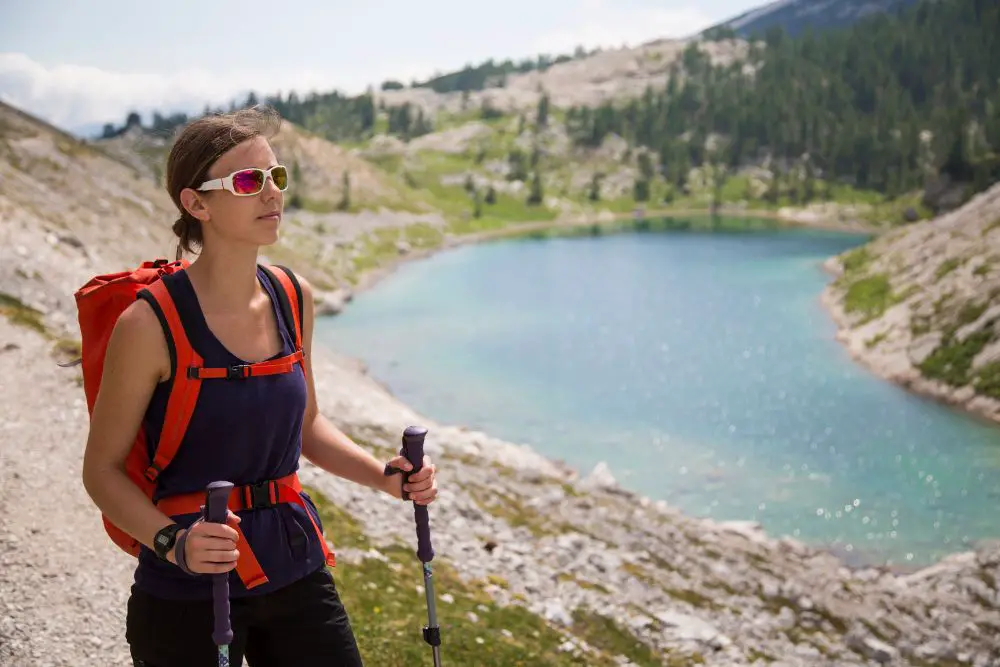 girl with hiking poles near the lake