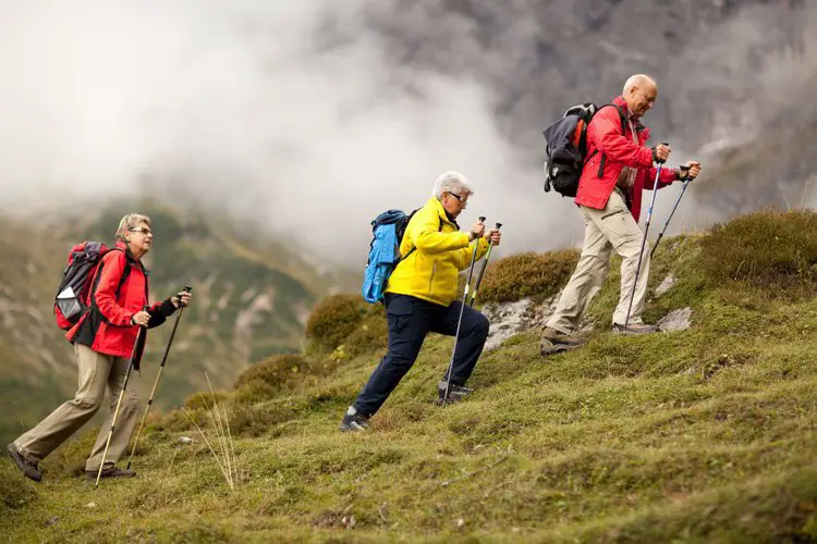 group of old people using hiking poles to go uphill