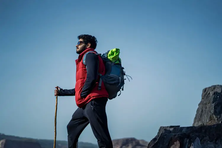 man goes hiking alone with a hiking backpack