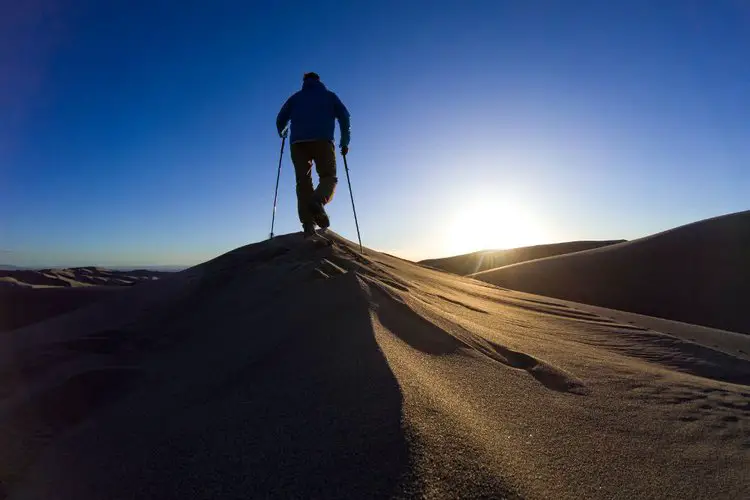 man goes hiking on sandy terrain