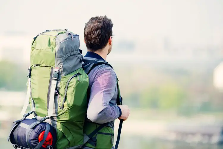 man wears mountaineering backpack