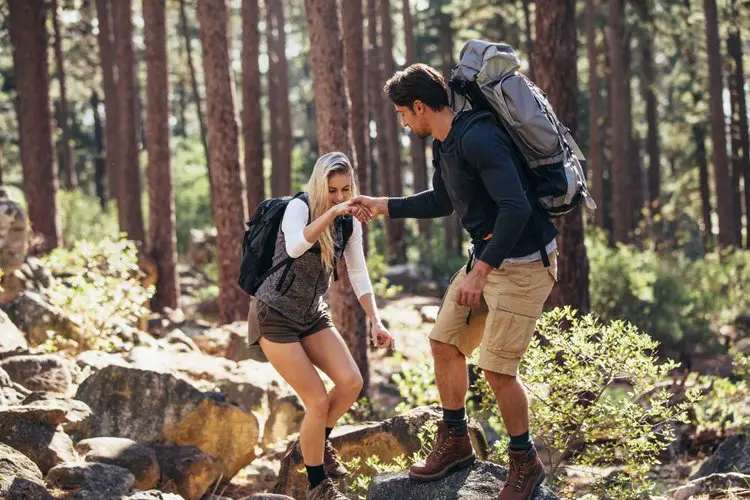 two hikers with hiking backpacks in the forest