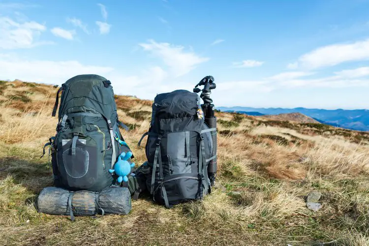 two hiking backpacks on the ground