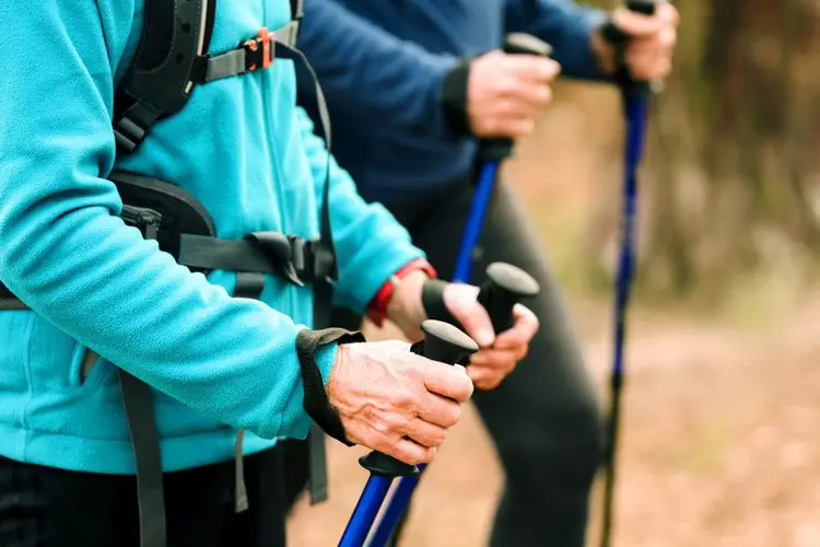 two peoples use the straps of hiking poles