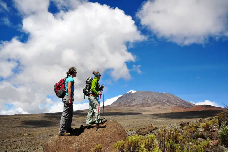 two women wear daypacks to go hiking on flat terrain