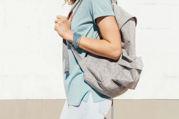 woman wears a regular backpack