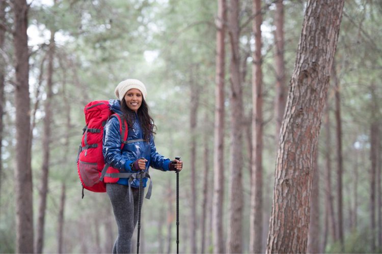 a woman with a big red hiking backpack in the forest